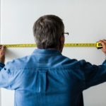 Man in blauw shirt meet een muur op